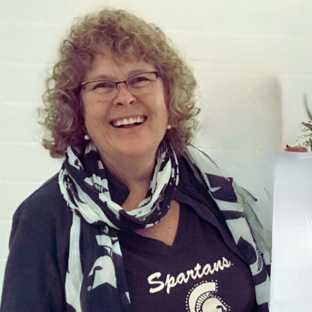 Pictured in action wearing an MSU Spartans shirt, Lori Strom Special Projects and Outreach Coordinator
